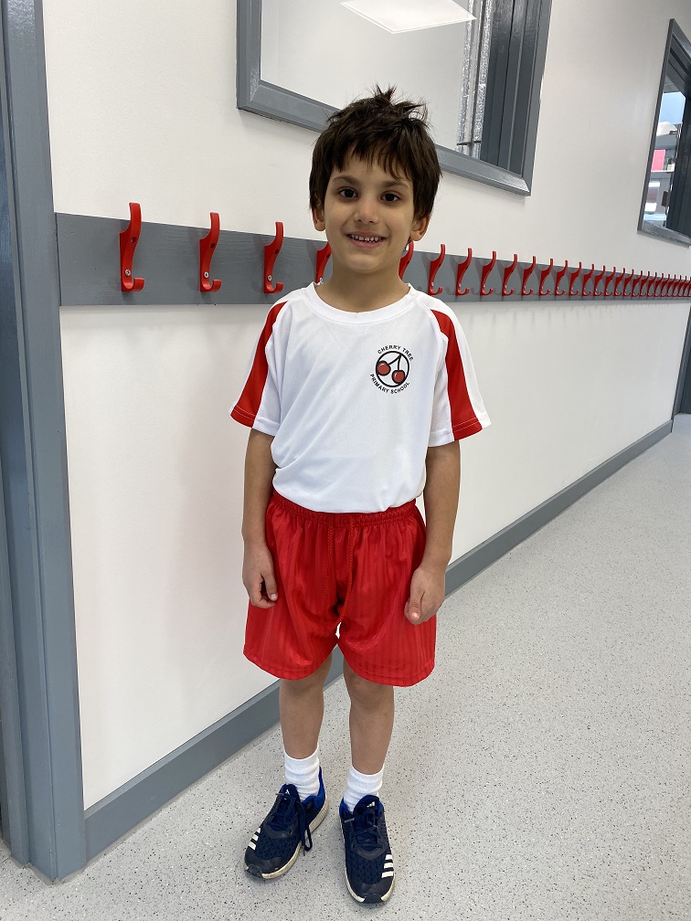 student stands in corridor wearing PE kit